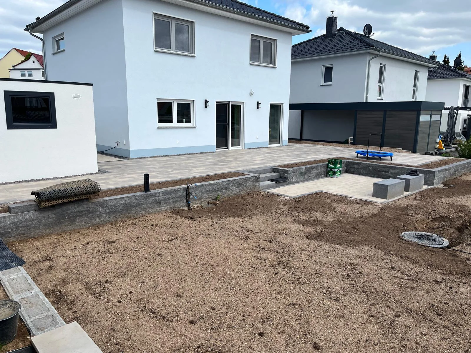 Große Pflasterterrasse mit Sitzmauer an einer modernen Stadtvilla